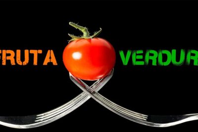 Tomate rojo equilibrado entre dos tenedores cruzados con las palabras FRUTA y VERDURA 0orlJllxrdY.