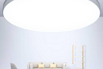 Lámpara de techo LED circular grande iluminando un salón minimalista con sofá y sillas