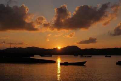 Atardecer sobre el agua con barcos y siluetas, accede aula virtual neil armstrong descubre vida logros