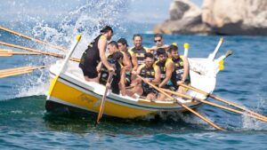 Remeros sincronizados en una embarcación amarilla remando con fuerza y salpicaduras, actividades deportivas arganda rey practicar.