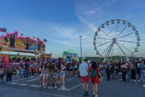 Familias y jóvenes en una feria con noria y atracciones, actividades divertidas en arganda del rey para ninos guia completa 2