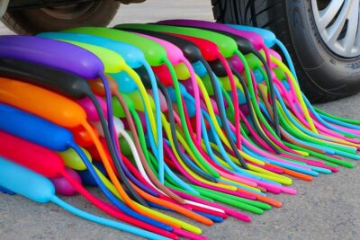 Montón de globos de agua coche multicolores junto a una rueda