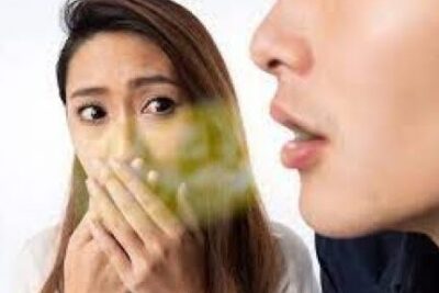 Mujer tapándose la boca ante el aliento personas 1 de otra persona.