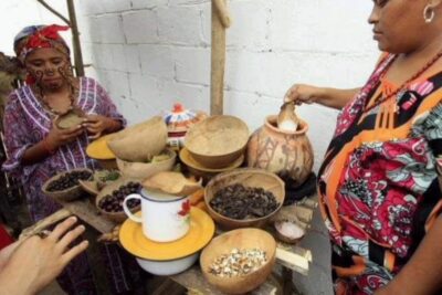 Mesa con vasijas de barro y cuencos con semillas y frutos mostrando la alimentacion wayuu tradicional