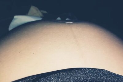 Primer plano de una barriga de embarazo mostrando el instante en que el bebe mueve con movimientos fetales perceptibles.