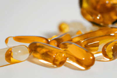 Capsulas omega 3 caducadas son seguras o deben evitarse: cápsulas blandas translúcidas amarillas esparcidas junto a un frasco