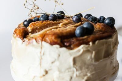 Tarta alta con glaseado blanco, plátanos caramelizados y arándanos frescos como hacer aji gallina light sabor tradicional