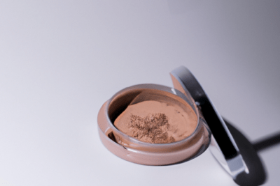 Envase abierto con base cremosa y superficie agrietada que muestra como saber si una base de maquillaje esta caducada