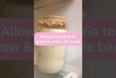 Frasco con kéfir de leche en fermentación cubierto con papel, contacto kefir en proceso