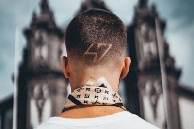 Joven de espaldas con diseño rasurado en la nuca frente a una iglesia explorando cual es significado numero