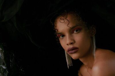 Retrato elegante con sombrero negro, maquillaje dramático y pendientes de perlas, definicion del numero 28 todo lo que necesitas saber 1