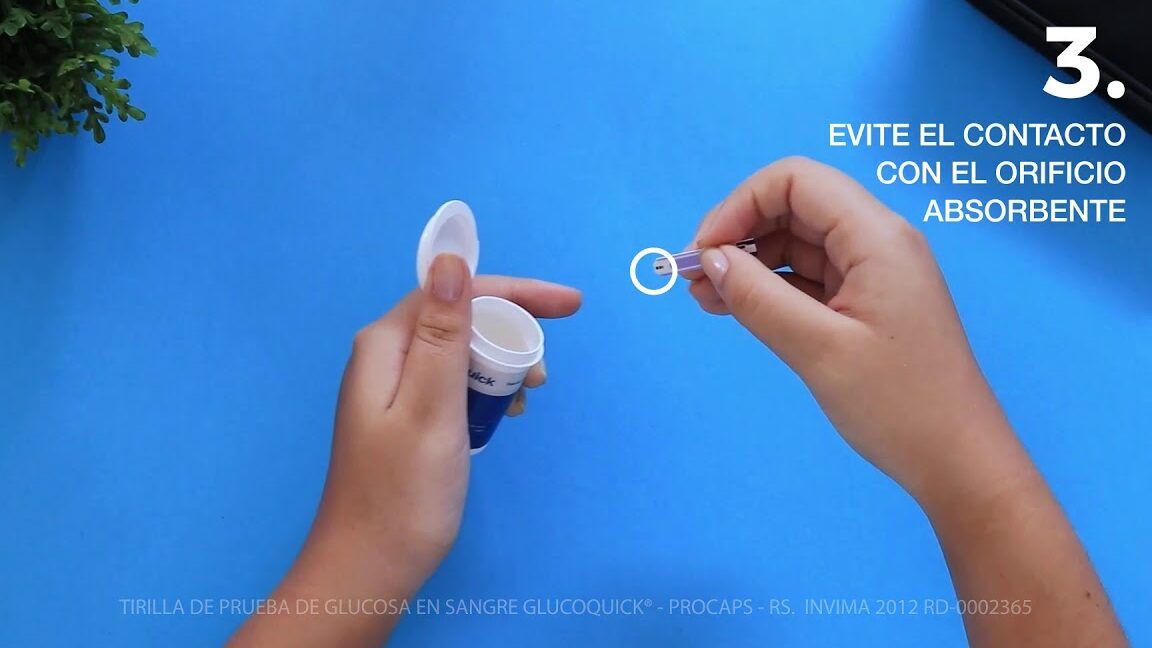 Manos sosteniendo un frasco de tirillas y una tira de prueba con la indicación de evitar el contacto con el orificio absorbente, descubre como usar el glucometro sd check y controla tu nivel de azucar en sangre 1.
