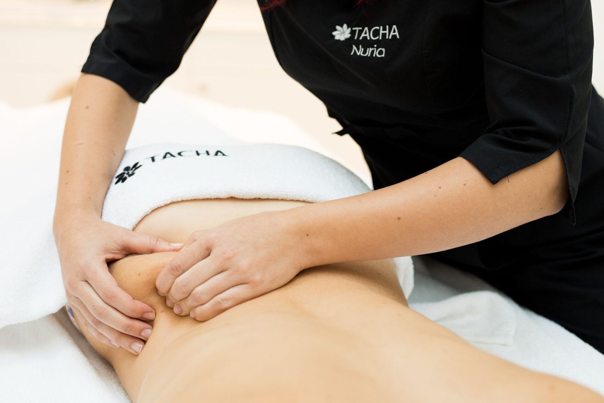 Masajista profesional aplica masaje terapéutico en la zona lumbar sobre una toalla blanca, descubre cual es el mejor esteroide para evitar la retencion de liquidos 1