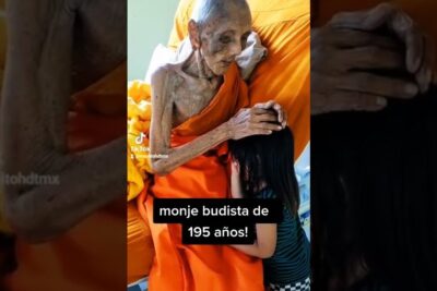 Monje budista anciano con túnica naranja colocando su mano sobre la cabeza de una niña, descubre el increible significado detras del numero 6