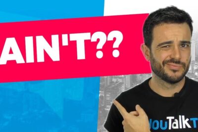 Hombre señalando un gran rótulo 'AIN'T??' sobre fondo azul y fucsia, descubre el significado de wanna en ingles y como utilizarlo correctamente