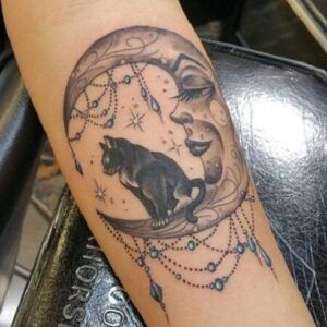 Descubre el significado del tatuaje de luna y estrella en la espalda: media luna con rostro, gato negro y cadenas de cuentas y estrellas