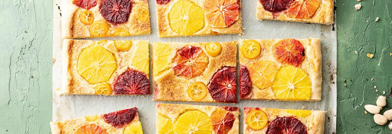 Barras de tarta de cítricos con rodajas de naranja y naranjas sanguinas sobre una bandeja, descubre los increibles beneficios de la zanahoria con limon para tu salud 1