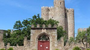 Entrada amurallada con arco y torreones de piedra bajo un cielo azul, descubre los principales atractivos turisticos de arganda del rey
