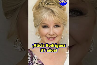 Mujer mayor sonriente con maquillaje y pendientes, cabello rubio recogido y fondo neutro, descubre que comen las cotorras verdes una guia completa sobre su alimentacion