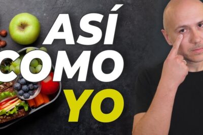 Persona junto a caja de comida con sándwich vegetal, frutas y frutos secos muestra opciones saludables; descubre que comen las personas veganas y como pueden mantener una dieta equilibrada.