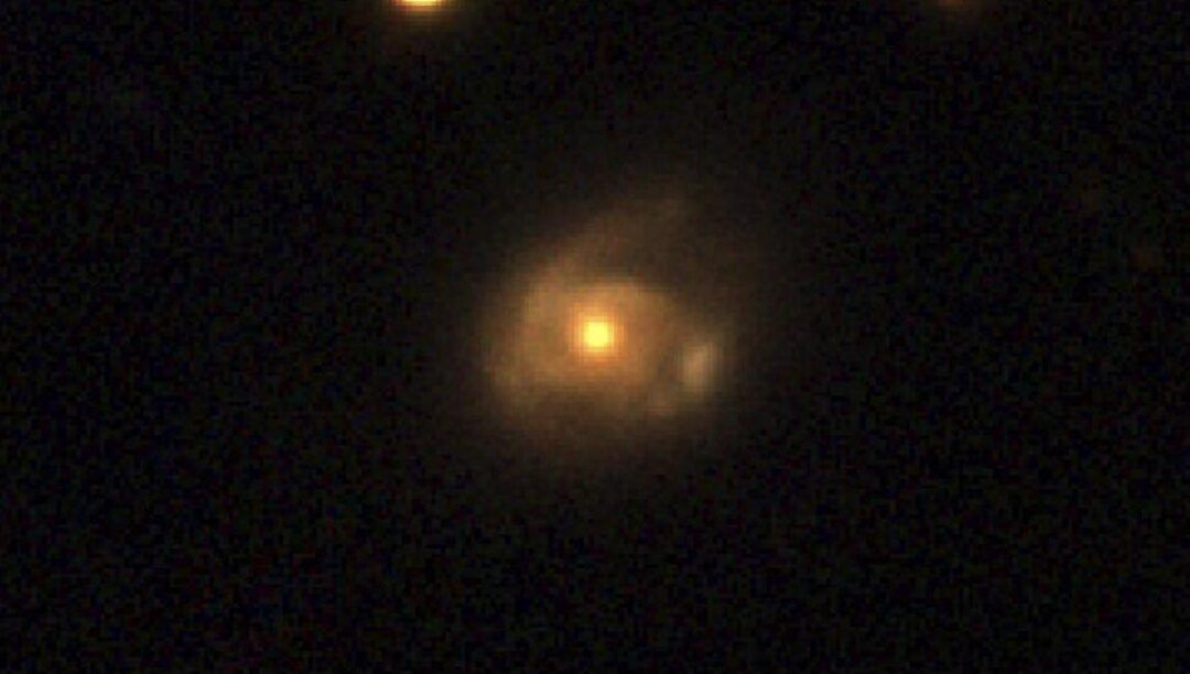 Esfera anaranjada brillante con halo nebuloso sobre fondo negro; descubre que ocurre al caer en un agujero negro en este juego.