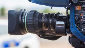 Cámara de video Canon en primer plano con lente zoom y controles visibles, descubre tatuaje media luna