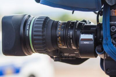 Cámara de video Canon en primer plano con lente zoom y controles visibles, descubre tatuaje media luna