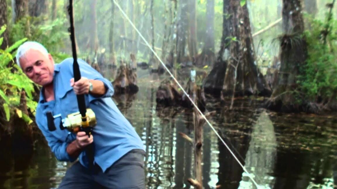 Pescador en un pantano con caña y carrete, imagen que ilustra descubriendo que comen las mojarras una guia completa