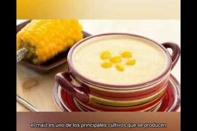 Tazón de sopa cremosa de maíz con granos decorativos y una mazorca al fondo, opción para dieta xincas