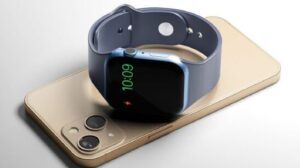 Reloj inteligente apoyado sobre un teléfono mostrando carga y tiempo, duracion de la bateria del apple watch consejos para prolongarla