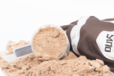 Polvo de proteína derramado junto a una cuchara y envase, ilustrando el mito sobre la whey protein caducada es seguro consumirla