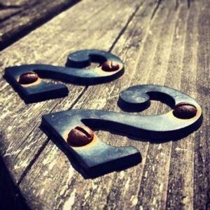 Dos dígitos metálicos en forma de '2' con tornillos sobre una tabla de madera, evocando el sentido del numero 22 que significa realmente 1.