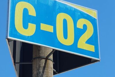 Cartel azul y amarillo con texto y números grandes montado en un poste sobre cielo despejado que sugiere el significado del numero simbolismo y misterio.