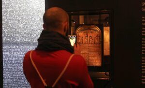 Visitante fotografía una estela con jeroglíficos en un museo, emoji guia completa para entender significado y uso