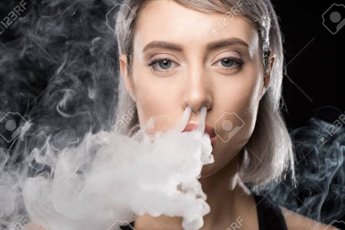 Persona en primer plano expulsando denso vapor por la nariz, es peligroso fumar vaper por la nariz descubre la verdad aqui