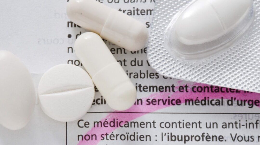 Es seguro combinar ibuprofeno y paracetamol en ninos descubre la respuesta aqui: pastillas blancas y blíster sobre un prospecto médico