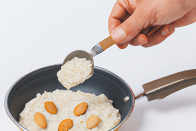 Es seguro consumir proteina caducada descubre la verdad aqui: mano sirviendo mezcla cremosa en sartén con almendras