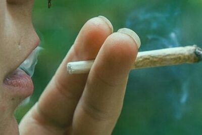 Primer plano de una persona fumando un cigarrillo enrollado, fumar con anginas verdes que consecuencias tiene para tu salud 1