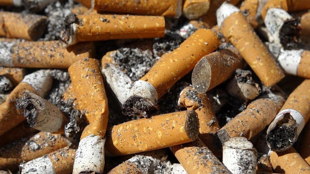 Montón de colillas y ceniza que ilustra que fumar un cigarrillo al mes de nicotina es peligroso para la salud