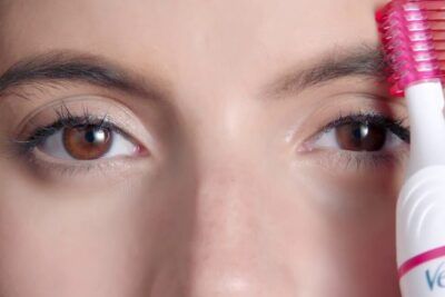Primer plano de ojos y cejas en proceso de depilación con herramienta eléctrica, guia completa como usar el creme depilatorio para rostro de avon 2