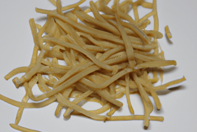 Montón de tiras que parecen gulas sobre fondo blanco como ilustración de gulas caducadas 5 dias es seguro consumirlas
