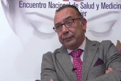 Hombre con traje y gafas en un encuentro de salud sobre hierro organismo