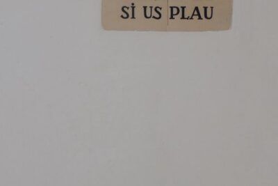 Placa cerámica con el texto 'SILENCI SI US PLAU' sobre pared blanca, hola en catalan descubre su significado palabras clave cataluna