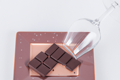 Plato con tabletas de chocolate y copa volteada que ilustra intoxicacion por chocolate caducado que debes saber