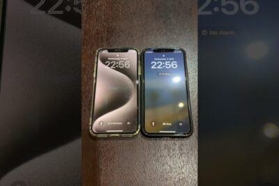 Dos teléfonos iPhone x 1 uno con funda transparente y otro con funda negra sobre una mesa de madera mostrando la pantalla de bloqueo