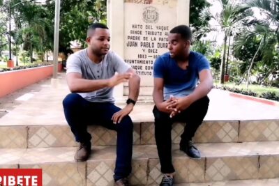 Dos hombres sentados en escalones frente a un monumento discutiendo un juzgado error