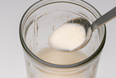 Kefir pastoret caducado es seguro consumirlo en un tarro transparente con una cuchara mostrando textura blanca y cremosa