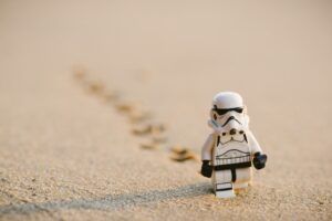 Minifigura tipo stormtrooper caminando sobre arena dejando huellas que evoca la fascinante historia lego.