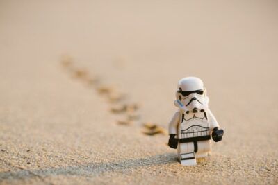 Minifigura tipo stormtrooper caminando sobre arena dejando huellas que evoca la fascinante historia lego.