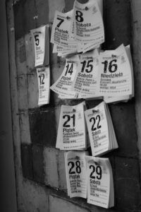 Hojas de calendario colgadas en pared en blanco y negro que muestran números grandes y sugieren la interpretacion del numero significado y simbolismo.